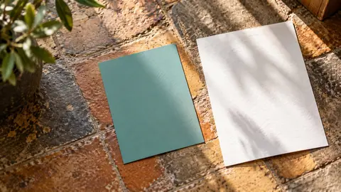 Échantillon de peinture et papier blanc posés près d'un carrelage pour comparer les sous-tons
